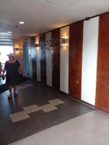 a woman walking down a hallway in a building at Tagaytay Prime Residences with Swimming Pool & Viewing Deck in Tagaytay