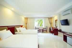 Cette chambre comprend deux lits et une télévision. dans l'établissement Sunshine Boutique Hotel Phu My Hung, à Hô-Chi-Minh-Ville