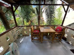 un tavolo e sedie in legno su un balcone con palme di Passion Nai Harn a Nai Harn Beach