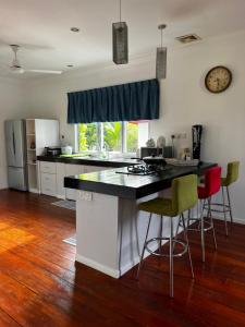 a kitchen with a counter and chairs in a room at LUMUN Holiday Home Rental in Penampang