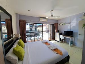 a bedroom with a large white bed and a balcony at Lily Holiday 百合假日 in Patong Beach
