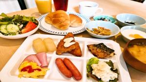 una mesa con un plato de comida con diferentes tipos de comida en APA Hotel Kumamoto Sakuramachi Bus Terminal Minami, en Kumamoto