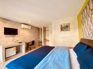 una camera d'albergo con un letto blu e una scrivania di The Curve Residence a Khao Tao