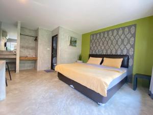 1 dormitorio con 1 cama grande y paredes verdes en The Curve Residence, en Khao Tao