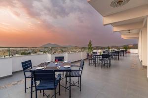 um restaurante com mesas e cadeiras numa varanda com vista em Maan Vilas By Stone Wood em Udaipur