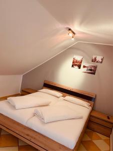 uma cama com lençóis brancos e almofadas num quarto em Landgasthof Scherer em Wenden