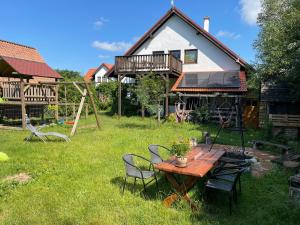 a backyard with a table and chairs and a house at Gospodarstwo Agroturystyczne Krzewinka in Giżycko