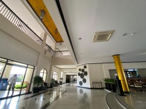 ein großes Gebäude mit einer Lobby mit Tischen und Stühlen in der Unterkunft Plaza Del Norte Hotel and Convention Center in Laoag