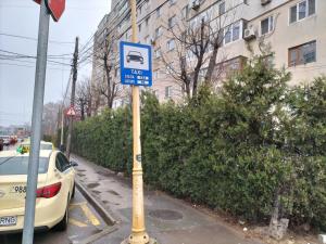 a blue sign on a pole next to a car at Apartament Luxury in Constanţa