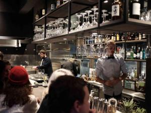 a chef standing at a bar in a restaurant at Chatrium Niseko Japan in Niseko