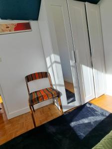 krzesło siedzące w pokoju z lustrem w obiekcie T2 AVEC TERRASSE w mieście Oloron-Sainte-Marie