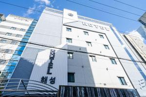 a white building with a sign on it at Hotel Haeseong in Changwon