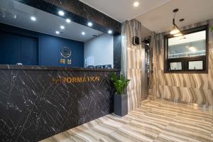 a lobby with a black counter and blue walls at Hotel Haeseong in Changwon