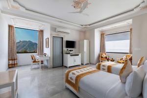 a hotel room with two beds and a desk and a table at Maan Vilas By Stone Wood in Udaipur