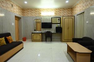 sala de estar con sofá y cocina en Hotel Komala Vilas, en Calcuta