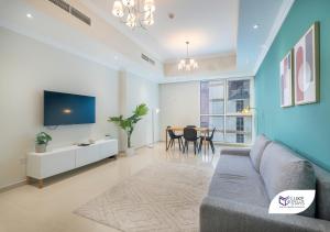 a living room with a couch and a tv at Luke Stays - Dunya Tower in Dubai