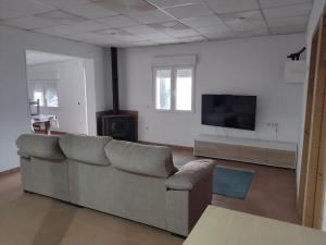 een woonkamer met een bank en een flatscreen-tv bij Alojamiento entero: chalet. in Alicante