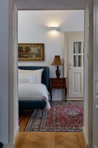 1 dormitorio con 1 cama y 1 mesa con lámpara en Vila Štiavnica, en Banská Štiavnica