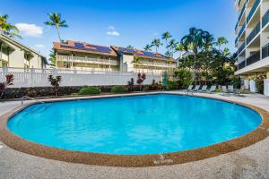 a swimming pool in front of a building at Kona Alii 201 in Kailua-Kona