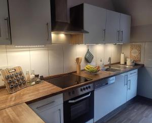 a kitchen with white cabinets and a counter top at Ferienwohnung Classen Eifel in Schleiden