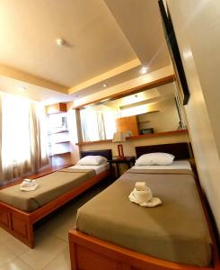 a bedroom with two beds with hats on them at FLOROTEL I in General Santos