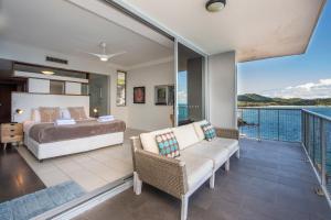 a bedroom with a bed and a balcony at 1 Bright Point Apartment 5404 in Nelly Bay