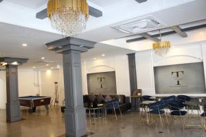 a lobby with tables and chairs and a chandelier at Talya Patong Hotel in Patong Beach