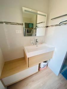 a bathroom with a white sink and a mirror at Face à la mer avec clim, wifi, parking in Le Barcarès