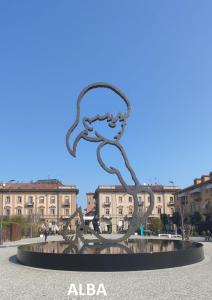 una estatua en una plaza con edificios en el fondo en Rossini15 - garage privato, en Alba