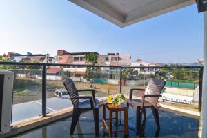 two chairs and a table on a balcony with a view at Dev1villa in Lonavala
