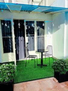 a patio with two chairs and a table on grass at Amy Hotel in Can Tho