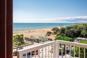 uma varanda com vista para a praia e para o oceano em Hotel Atlantic em Lignano Sabbiadoro
