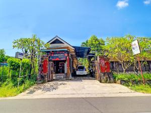 un edificio con un'auto parcheggiata di fronte di SPOT ON 92399 Hotel Sekar Jagat Near Pantai Baluk Rening a Negara