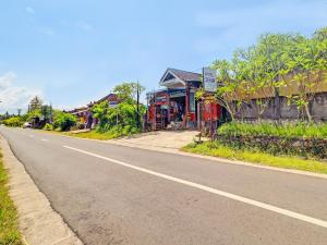 an empty road in a village with houses at SPOT ON 92399 Hotel Sekar Jagat Near Pantai Baluk Rening in Negara