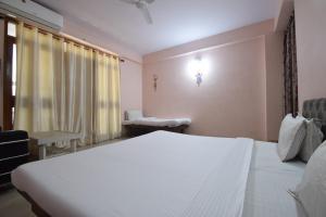 Un dormitorio con una gran cama blanca y una ventana en Shreenath JI inn en Udaipur