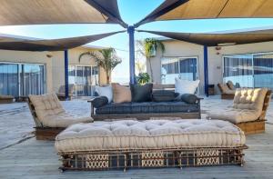 a patio with three couches and an umbrella at Top of the cliff apartments - Metzoke Dragot in Metsoke Dragot