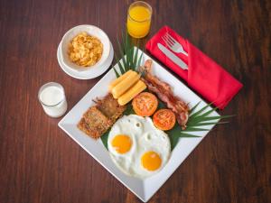 a plate of breakfast food with eggs bacon and toast at Chateau d'Angkor La Residence in Siem Reap