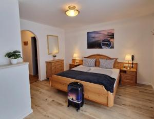 ein Schlafzimmer mit einem Bett und einem Koffer auf dem Boden in der Unterkunft HoFer am Zeitberg Ferienwohnung Lindenbach in Bad Kohlgrub
