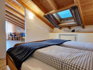 1 dormitorio con 1 cama en una habitación con techos de madera en HoFer am Zeitberg Ferienwohnung Kindelsbach, en Bad Kohlgrub