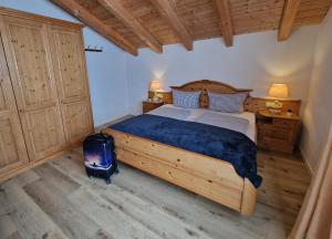 Un dormitorio con una cama y una maleta. en HoFer am Zeitberg Ferienwohnung Falleralm, en Bad Kohlgrub