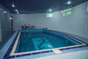 una piscina con una persona en el agua en Panorama Villa Lux Hotel en Bakú