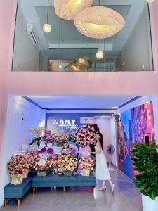a woman is standing in front of a flower shop at Amy Hotel in Can Tho