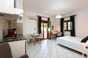 a living room with a bed and a kitchen and a room with a kitchen gmaxwell at Carpe Diem Apartment in Balíon