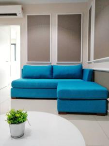 um sofá azul numa sala de estar com uma planta em Luxury Blue Paris Suite # I-City # Free Wifi + Free Parking [1r1b] em Shah Alam