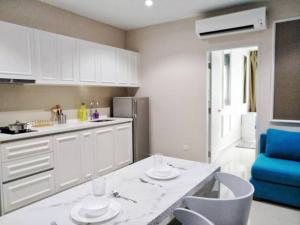 uma cozinha com armários brancos e uma mesa e cadeiras em Luxury Blue Paris Suite # I-City # Free Wifi + Free Parking [1r1b] em Shah Alam