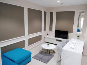 uma sala de estar com um banco azul e uma televisão em Luxury Blue Paris Suite # I-City # Free Wifi + Free Parking [1r1b] em Shah Alam