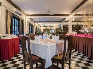 a dining room with a table with a white table cloth at Chateau d'Angkor La Residence in Siem Reap