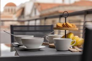 a table with three cups and a tray of pastries at Aeson Premium Living in Volos