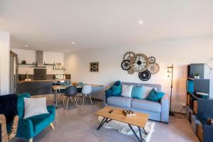 ein Wohnzimmer mit einem blauen Sofa und einem Tisch in der Unterkunft O Ciucciarella - Appt climatisé pour 4 in Grosseto-Prugna