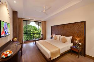a bedroom with a large bed and a large window at Rio Boutique in Candolim